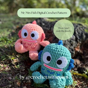 Op de afbeelding: Twee handgemaakte gehaakte visjes in roze en blauwgroen. De vissen hebben grote witte ogen, rode monden en blauwe accenten. De afbeelding bevat de tekst "Mr/Mrs Fish Digital Crochet Pattern" en "by @crochet.withmimi".