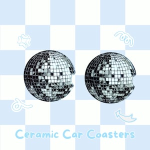 May include: Two ceramic car coasters with a disco ball design. The coasters are round with a cutout on one side. The disco ball design is made of small, reflective squares. The text "Ceramic Car Coasters" is in light blue.