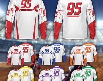 Könnte beinhalten: Weißes Langarm-Trikot mit roten Akzenten, das die Nummer 95 in Rot zeigt. Das Trikot enthält den Text "YOUR TEXT" und "YOUR NAME". Weitere Trikots in Blau, Orange, Gelb, Lila und Grün sind ebenfalls abgebildet.