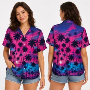 Puede incluir: Una camisa de manga corta con botones y un estampado vibrante de atardecer tropical, con siluetas de palmeras sobre un degradado de rosa, morado y azul. La camisa presenta un cuello clásico y un cierre frontal de botones con un patrón continuo.