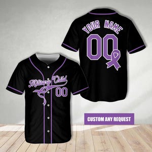 Puede incluir: Camiseta de béisbol negra con detalles morados. El frente muestra "Military Child" y el número "00". La parte trasera tiene "YOUR NAME", el número "00" y una cinta morada. La parte inferior de la imagen dice "CUSTOM ANY REQUEST".