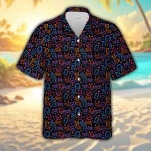 May include: A short-sleeved button-down shirt with a black background featuring a repeating neon-colored pattern of video game controllers, handheld consoles, headsets, and small hearts in shades of blue, purple, orange, and pink.