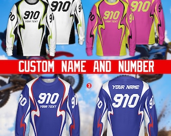 Könnte beinhalten: Langärmlige Motocross-Trikots in Weiß, Pink und Blau, jeweils mit individuellem Namen und Nummer. Die Trikots verfügen über auffällige Grafiken, darunter die Nummer "910" und der Text "YOUR TEXT". Der Satz "CUSTOM NAME AND NUMBER" wird angezeigt.