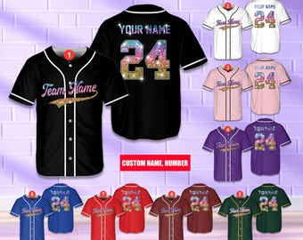 Pode incluir: Camisas de beisebol em várias cores, incluindo preto, branco, rosa, roxo, vermelho e verde. Cada camisa apresenta um nome personalizado e o número 24 em um design brilhante. O texto "Team Name" também é exibido.