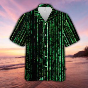 May include: Black short-sleeved shirt with a green digital rain design. The shirt has a classic collar and button closure. The pattern resembles computer code, with green characters on a black background.