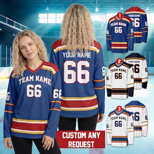 May include: A blue hockey jersey with white and red accents. The jersey features the text "TEAM NAME" and the number "66" on the front. The back of the jersey displays "YOUR NAME" and the number "66". Additional jerseys in red, white, and black are also shown.
