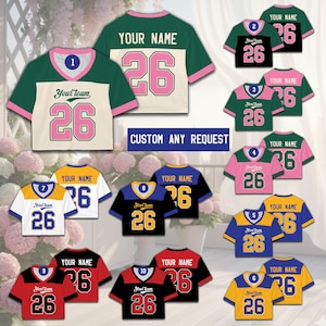 May include: A collection of custom-designed athletic jerseys in various color combinations. Each jersey features a number "26" and the text "Your Team" or "Your Name". The jerseys are displayed against a floral background, with the text "CUSTOM ANY REQUEST".