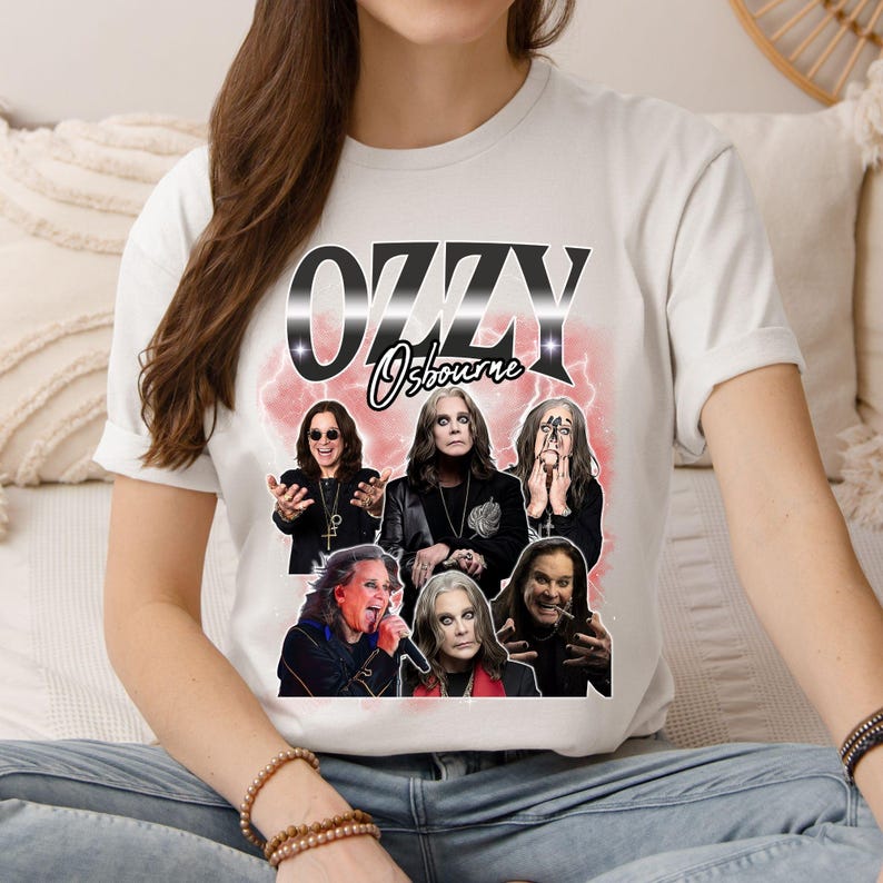 Puede incluir: Camiseta blanca con un dise&ntilde;o de Ozzy Osbourne. El dise&ntilde;o presenta el texto "OZZY Osbourne" en una fuente estilizada, junto con m&uacute;ltiples im&aacute;genes del m&uacute;sico sobre un fondo rosa y blanco.