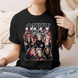 May include: Black t-shirt featuring a graphic of Ozzy Osbourne and the text "OZZY Osbourne" in a silver and white font. The graphic includes multiple images of the musician with a red lightning bolt background.