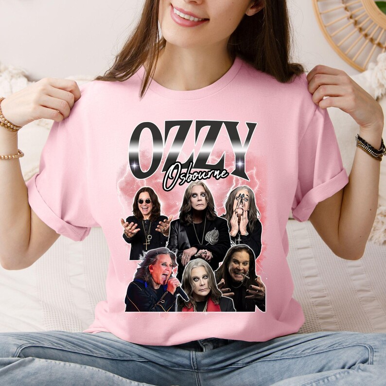 Puede incluir: Camiseta rosa claro con un dise&ntilde;o de Ozzy Osbourne. El dise&ntilde;o presenta el nombre "OZZY" en plata y negro, junto con m&uacute;ltiples im&aacute;genes del m&uacute;sico. La camiseta est&aacute; hecha de una tela suave.