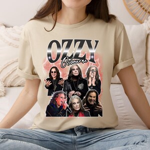 Puede incluir: Camiseta beige con un dise&ntilde;o gr&aacute;fico de Ozzy Osbourne. El texto "OZZY Osbourne" es plateado y negro. El dise&ntilde;o incluye m&uacute;ltiples im&aacute;genes de Ozzy Osbourne con un fondo de rel&aacute;mpagos rojos.