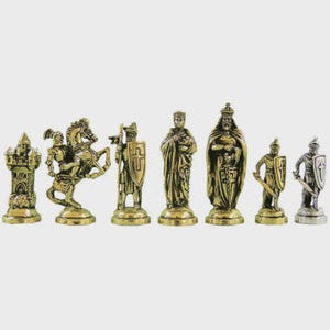 May include: A set of chess pieces with a medieval theme. The pieces are made of gold and silver-colored metal and include a castle, knight on horseback, king, queen, and pawns. The chess set is displayed on a light gray surface.