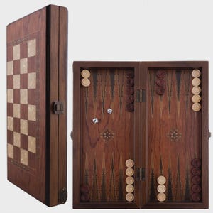 May include: A wooden backgammon and chess set. The backgammon board is open, displaying a dark brown playing surface with white and brown checkers and dice. The closed set shows a chess board with light and dark squares.