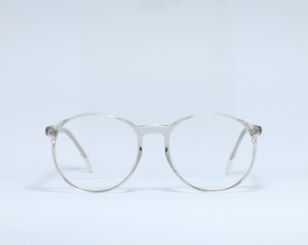May include: Clear plastic framed round glasses with a silver tint.