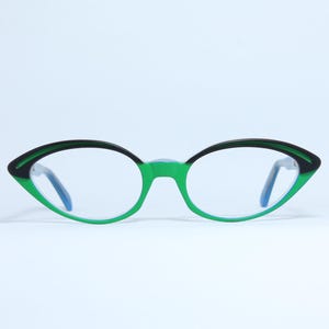 May include: Green and black cat eye glasses with blue arms.