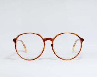 Puede incluir: Un par de gafas redondas de carey con lentes transparentes.