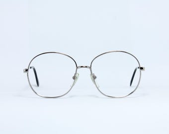 Puede incluir: Gafas redondas con lentes transparentes y montura plateada.