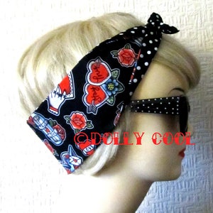 May include: A black and white polka dot headband with a black fabric featuring red hearts, roses, and other tattoo-style designs. The headband is tied in a knot at the top.