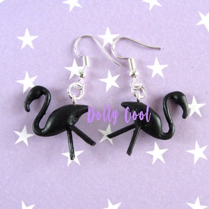May include: A pair of black flamingo earrings with silver hooks. The earrings are made of polymer clay and are about 1 inch tall.