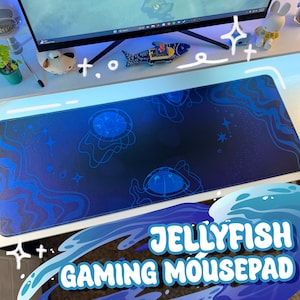 May include: A blue gaming mousepad with a jellyfish design. The mousepad has a dark blue background with light blue jellyfish illustrations and wave patterns. The text "JELLYFISH GAMING MOUSEPAD" is displayed in white and blue.