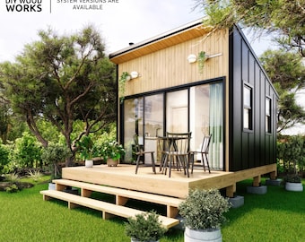 May include: A small, modern cabin with a black and wood exterior, a wooden deck, and a small patio set. The cabin is surrounded by green grass and trees. The text "METRIC & IMPERIAL SYSTEM VERSIONS ARE AVAILABLE" is displayed above the cabin.