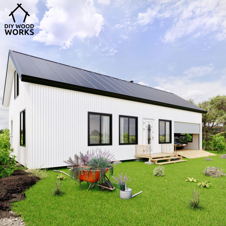 May include: A white modern house with a black roof and a garage door. The house has a porch with a wooden deck and steps. There is a wheelbarrow with flowers in front of the house.