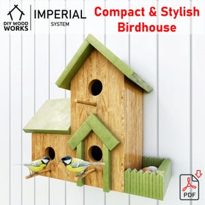 Puede incluir: Una casita de pájaros de madera con dos compartimentos de anidación y una pequeña valla verde en la parte inferior. La casita tiene un techo verde y está pintada de marrón. Dos pájaros pequeños están posados en las ramas delante de la casita.