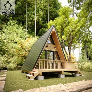 May include: A small, wooden A-frame cabin with a green metal roof and a wooden deck. The cabin is surrounded by trees and grass.