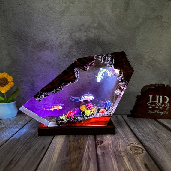 A hand-cast resin axolotl glows inside a miniature underwater diorama — it's equal parts night light and tiny aquatic sculpture.