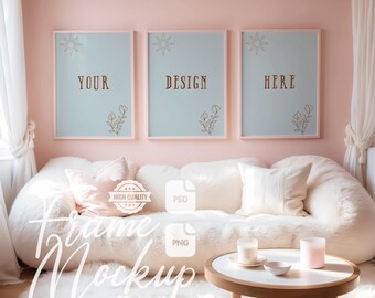 May include: A mockup featuring three framed art prints with the words "YOUR", "DESIGN", and "HERE" in brown text. The frames are light pink, and the prints have a light blue background with floral and sun designs. A white sofa and a round table are in the foreground.