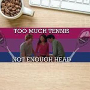 May include: A sticker with a bi-colored background of pink and blue with a white stripe in the middle. The sticker features two tennis rackets with the text "Too Much Tennis Not Enough Head" in white.