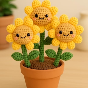 Op de afbeelding: Een handgemaakt gehaakt zonnebloemarrangement in een terracotta pot. De zonnebloemen hebben gele bloemblaadjes, lachende gezichten en groene stelen met bladeren. De pot is gevuld met bruin garen.