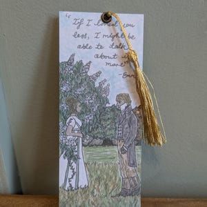May include: A bookmark with a hand-drawn illustration of a couple standing in a garden. The bookmark features a quote from the novel "Emma" by Jane Austen: "If I loved you less, I might be able to talk about it more." -Emma