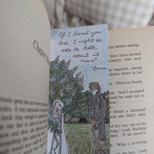 May include: A bookmark featuring a hand-drawn illustration of two people standing in a garden setting. The woman is wearing a white dress and the man is wearing a dark suit. The bookmark includes a quote from the book "Emma" by Jane Austen: "If I loved you less, I might be able to talk about it more." -Emma