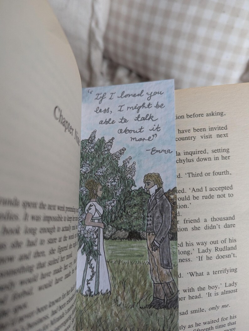 May include: A bookmark featuring a hand-drawn illustration of two people standing in a garden setting. The woman is wearing a white dress and the man is wearing a dark suit. The bookmark includes a quote from the book "Emma" by Jane Austen: "If I loved you less, I might be able to talk about it more." -Emma