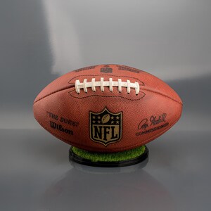 NFL football display stand with a sturdy black base, designed to hold and showcase a full-size American football vertically or horizontally, ideal for sports memorabilia display.
