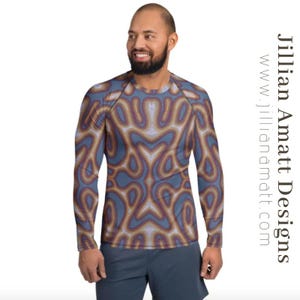 May include: A long-sleeve shirt with a blue, brown, and purple abstract pattern. The shirt has a crew neck and is worn with blue shorts. The text "Jillian Amatt Designs" and website address are visible.