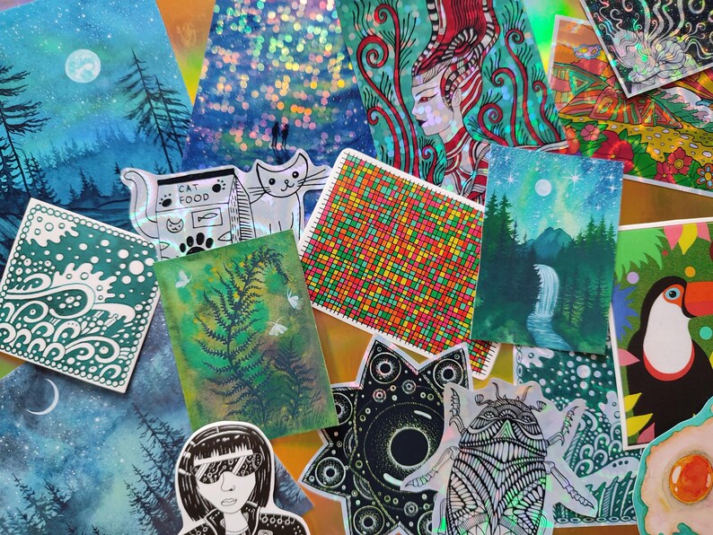 May include: A collection of colorful art prints and stickers. The prints feature various designs, including landscapes with trees and waterfalls, a cat, a fern, and a woman with sunglasses. The stickers include a toucan and a geometric design.