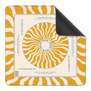 May include: A square mousepad with a retro design. The mousepad features a cream-colored center with a radiating sunburst pattern in yellow. The border is yellow with wavy lines. Text includes "WALLS PLAY" and "MAHJ".