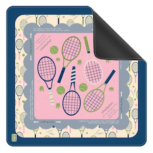 May include: A rectangular tennis-themed mat with a navy blue border. The center features tennis rackets, balls, and text on a pink background. The text includes "Charleston" and "walls play". The mat has a scalloped edge and a black backing.