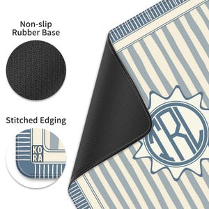 K&ouml;nnte beinhalten: Eine Mausunterlage mit blau-cremefarbenem Streifenmuster und einem kreisf&ouml;rmigen Monogramm-Design. Sie hat eine rutschfeste Gummiunterseite und eine eingefasste Kante. Der Text "KO RA" ist am Rand sichtbar.