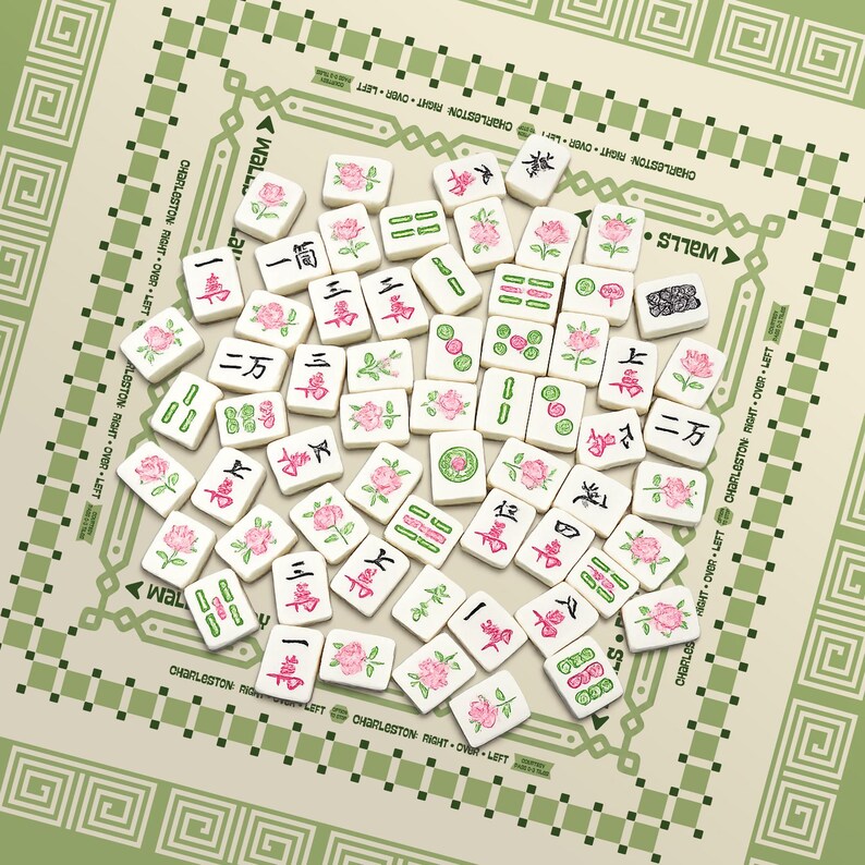 K&ouml;nnte beinhalten: Eine Sammlung wei&szlig;er Mahjong-Steine mit roten und gr&uuml;nen chinesischen Schriftzeichen und rosa Blumendesigns. Die Steine liegen auf einem gr&uuml;nen und beigen Spielbrett mit dekorativen R&auml;ndern und dem Text "Charleston Right Over Left".