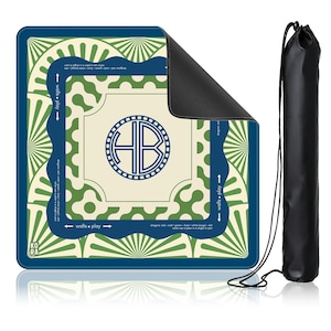 May include: A square, cream-colored play mat with a blue border and green accents. The mat features a circular design with the letters "HB" inside. A black carrying bag is included. The mat has the text "walls + play" and "KORA".