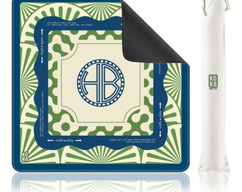 May include: A square game mat with a navy blue, cream, and green geometric pattern featuring a central circular monogram with the letters HB. The mat includes text reading walls play and KORA MAT CO, accompanied by a matching white drawstring storage bag.