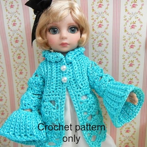 Puede incluir: Patrón de ganchillo para una chaqueta de muñeca turquesa con mangas acampanadas y botones de perla. "Crochet pattern only" está escrito debajo de la muñeca.