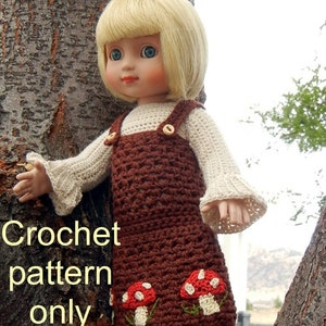 May include: Crochet pattern for a brown doll dress with mushroom embroidery. The dress has a white crocheted top and brown straps. "Crochet pattern only" is written in yellow text on the image.