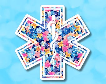 May include: A white star of life sticker with a floral pattern in shades of pink, blue, and yellow. The star of life is a symbol used by emergency medical services.