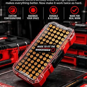 May include: A red and clear plastic storage case filled with brass-cased ammunition. The case features the text MADE TO FIT THE SHOCKWAVE and is displayed against a background with promotional text including CUSTOM CONFIGURATIONS and MADE IN TEXAS.