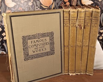 May include: A collection of antique books titled "Famous Composers and Their Works." The books have aged, tan covers with gold lettering and decorative borders. The spines of the books are visible, with the titles and volume numbers. The large book on the left has the title in a decorative frame.