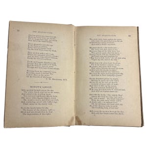 May include: Open book with aged, yellowed pages. Text is visible on both sides, with titles like "THE READING-CLUB" and "MINOT'S LEDGE." The pages are slightly curled, suggesting age and use. The book is open to display the text.